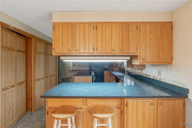 3643 Armstrong Rd, Camillus, NY 13209 - kitchen featuring a peninsula, a sink, a breakfast bar, dark countertops, and light tile patterned flooring