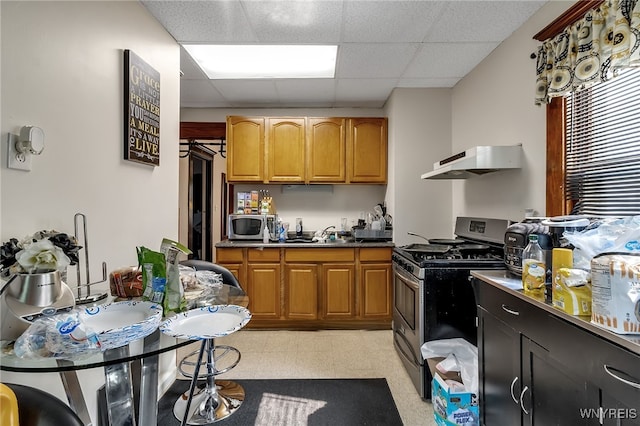 1244 Kenmore Ave, Buffalo, NY 14216 - kitchen featuring stainless steel appliances, under cabinet range hood, a drop ceiling, and brown cabinets