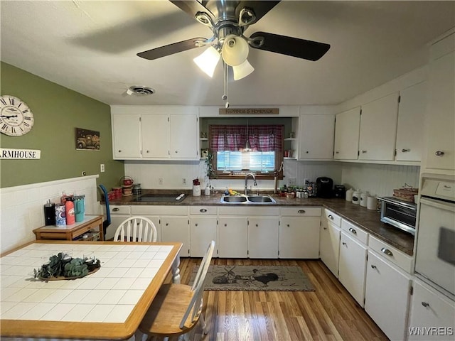 48 Ward Ct, Buffalo, NY 14220 - kitchen featuring a sink, wood finished floors, white cabinetry, white oven, and ceiling fan