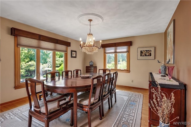 9325 Hunting Valley Rd N, Clarence, NY 14031 - dining room with healthy amount of natural light, a chandelier, and light wood-style flooring