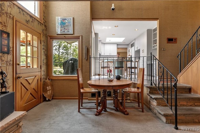 9325 Hunting Valley Rd N, Clarence, NY 14031 - carpeted dining room with stairs, a skylight, and a high ceiling