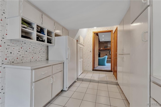 9325 Hunting Valley Rd N, Clarence, NY 14031 - kitchen with freestanding refrigerator, light countertops, open shelves, light tile patterned flooring, and white cabinets