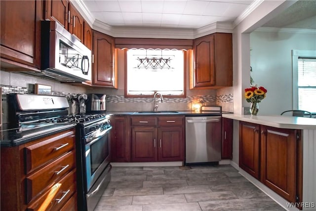 2019 Center St, North Collins, NY 14111 - kitchen featuring appliances with stainless steel finishes, a sink, ornamental molding, a peninsula, and backsplash