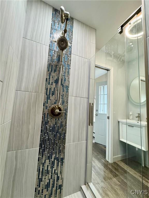 10 Litwak St, Fulton, NY 13069 - full bath with a stall shower, vanity, and wood finished floors