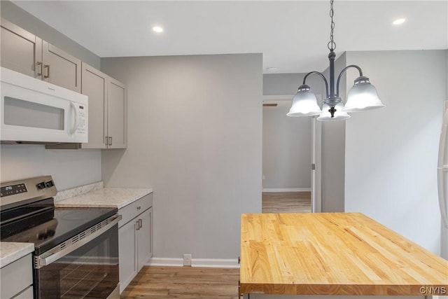 7-9 Tappan St Unit 7, Van Buren, NY 13027 - kitchen with stainless steel range with electric stovetop, white microwave, light wood-style floors, recessed lighting, and a chandelier