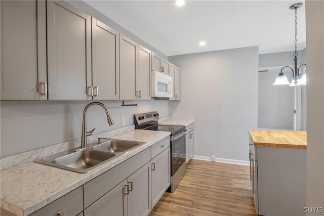 7-9 Tappan St Unit 7, Van Buren, NY 13027 - kitchen featuring stainless steel range with electric cooktop, white microwave, a sink, wooden counters, and light wood-style floors