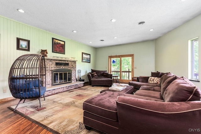 2260 Lamson Rd, Lysander, NY 13135 - living area featuring wood finished floors, a brick fireplace, a textured ceiling, and recessed lighting