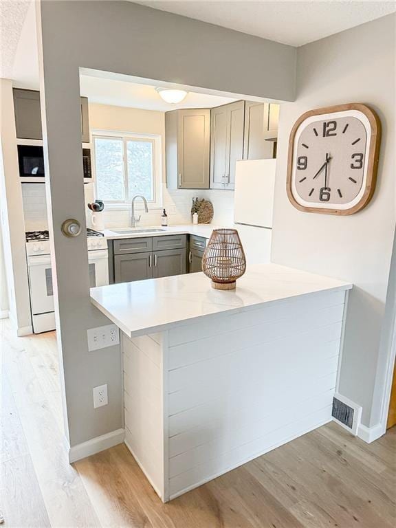 90 Fox Run, Gates, NY 14606 - kitchen featuring a sink, gray cabinets, light wood-type flooring, and light countertops