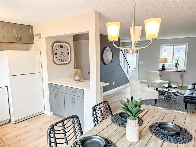 90 Fox Run, Gates, NY 14606 - dining room with light wood-style flooring, baseboards, a chandelier, and stairs