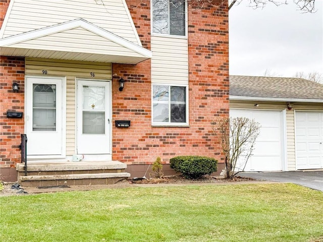 90 Fox Run, Gates, NY 14606 - view of exterior entry featuring asphalt driveway, brick siding, a lawn, and a garage