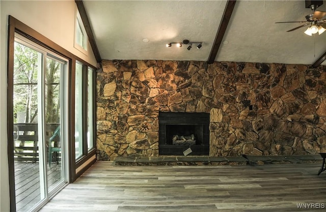 1763 Lake Rd, Porter, NY 14174 - unfurnished living room featuring wood finished floors, a ceiling fan, a fireplace with raised hearth, and vaulted ceiling