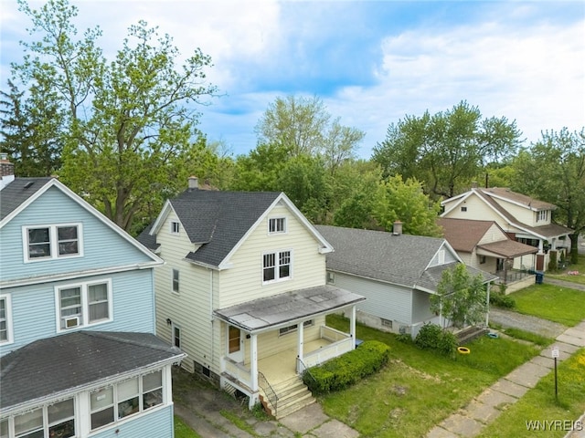 2215 S Ave, Niagara Falls, NY 14305 - view of front of house featuring covered porch, a front yard, a shingled roof, and view of wooded area
