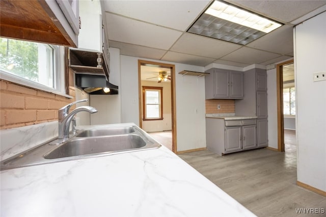 2215 S Ave, Niagara Falls, NY 14305 - kitchen featuring gray cabinets, a sink, light wood-style floors, light countertops, and a drop ceiling