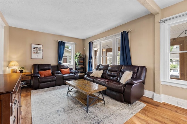 24 Spencer Rd, Irondequoit, NY 14609 - living room featuring light wood finished floors, baseboards, and a textured ceiling