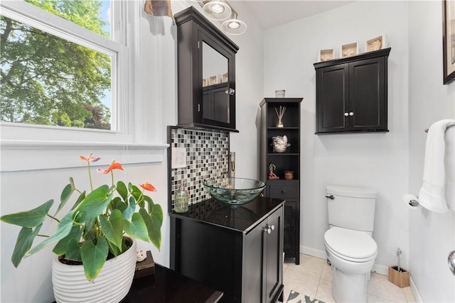 24 Spencer Rd, Irondequoit, NY 14609 - half bath with vanity, toilet, tasteful backsplash, tile patterned flooring, and baseboards