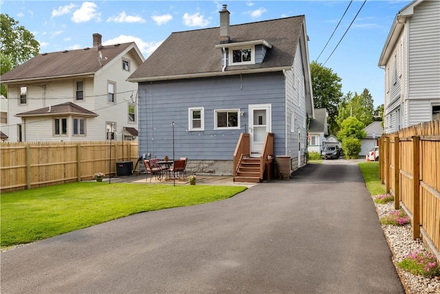 24 Spencer Rd, Irondequoit, NY 14609 - back of house featuring a chimney, central AC unit, roof with shingles, and a patio area
