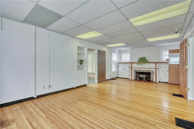 1845 N Clinton Ave, Rochester, NY 14621 - unfurnished living room featuring wood finished floors, a brick fireplace, a paneled ceiling, baseboards, and built in features