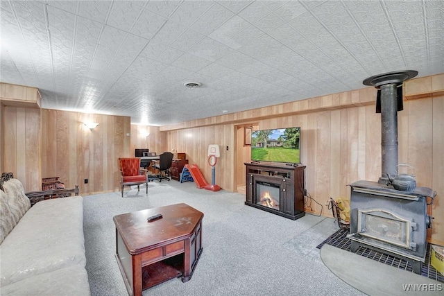 100 Brompton Rd, Amherst, NY 14221 - carpeted living area with a wood stove, a glass covered fireplace, wood walls, and an office area