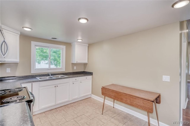 4356 Redman Rd, Sweden, NY 14420 - kitchen with white cabinets, dark countertops, range with electric stovetop, and light tile patterned floors