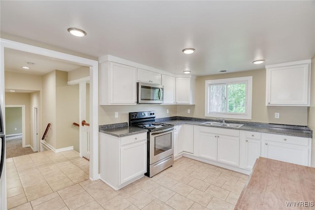 4356 Redman Rd, Sweden, NY 14420 - kitchen featuring stainless steel appliances, white cabinets, light tile patterned flooring, and dark countertops