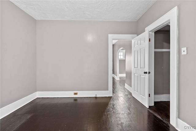 402 Cogswell Ave, Geddes, NY 13209 - spare room with hardwood / wood-style floors, a textured ceiling, baseboards, and arched walkways