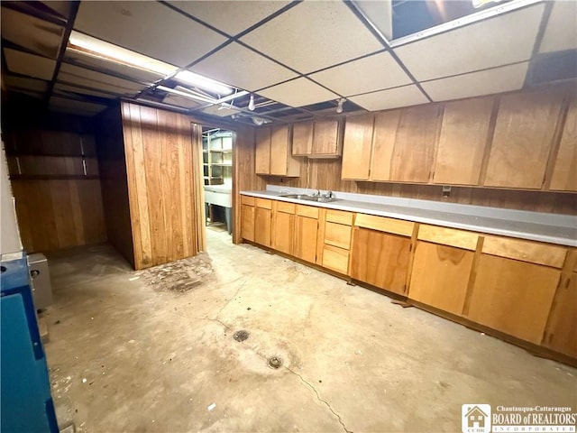 56 Otter St, Dunkirk-City, NY 14048 - kitchen featuring unfinished concrete flooring, light countertops, a drop ceiling, and wood walls