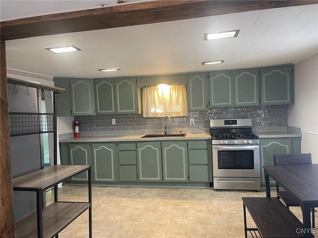 207 E Elm St, Oneida-Inside, NY 13421 - kitchen featuring green cabinetry, stainless steel gas range, a sink, light countertops, and tasteful backsplash