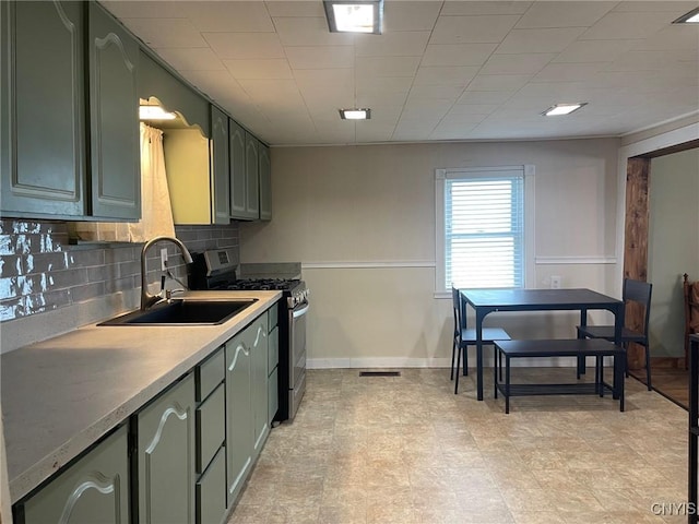 207 E Elm St, Oneida-Inside, NY 13421 - kitchen featuring a sink, stainless steel gas range, tasteful backsplash, light countertops, and baseboards