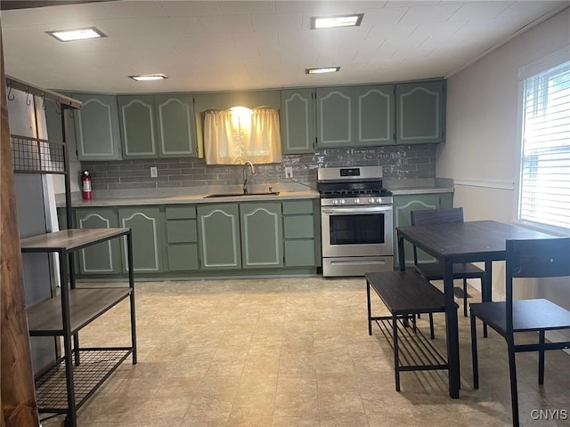 207 E Elm St, Oneida-Inside, NY 13421 - kitchen with green cabinetry, stainless steel gas range, a sink, light countertops, and tasteful backsplash