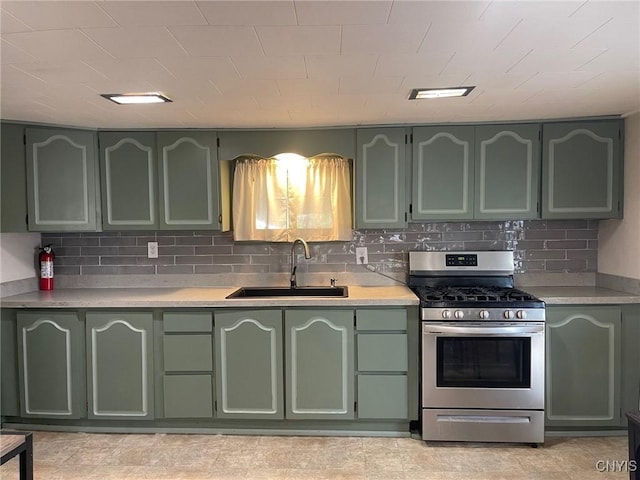 207 E Elm St, Oneida-Inside, NY 13421 - kitchen featuring green cabinetry, stainless steel gas range oven, a sink, light countertops, and tasteful backsplash
