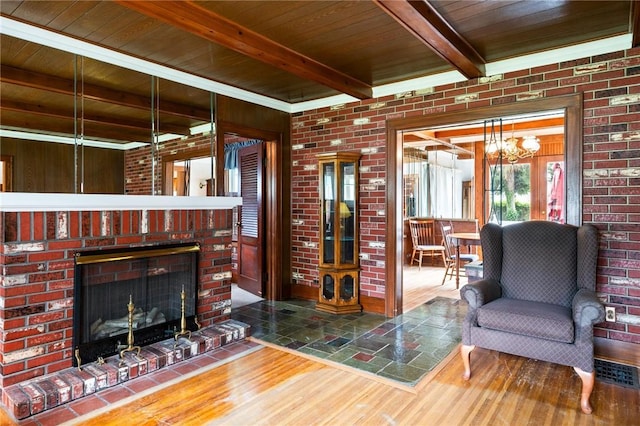 377 Winfield Rd, Irondequoit, NY 14622 - living area with wood finished floors, wooden ceiling with exposed beams, a fireplace, and brick wall