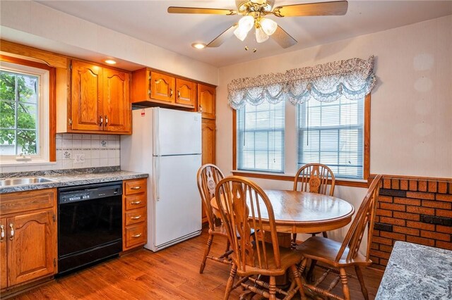 377 Winfield Rd, Irondequoit, NY 14622 - kitchen featuring black dishwasher, freestanding refrigerator, brown cabinets, wood finished floors, and tasteful backsplash