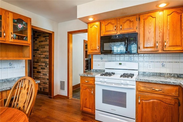 377 Winfield Rd, Irondequoit, NY 14622 - kitchen featuring black microwave, white range with gas cooktop, dark wood-style flooring, decorative backsplash, and brown cabinetry