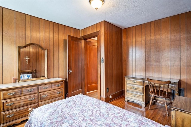 377 Winfield Rd, Irondequoit, NY 14622 - bedroom with wood finished floors, wooden walls, a textured ceiling, an office area, and baseboards