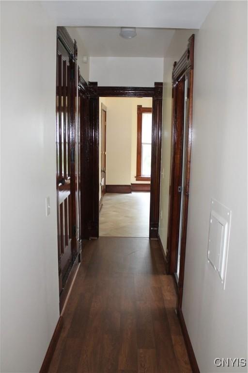 42 Mechanic St, Elbridge, NY 13080 - hall featuring a barn door, wood finished floors, and baseboards