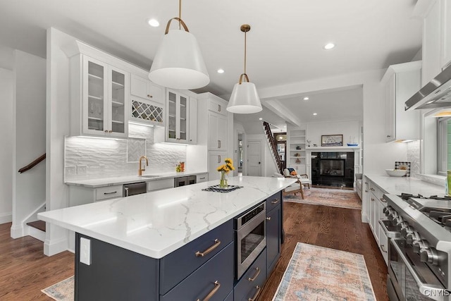 149 E Genesee St, Skaneateles, NY 13152 - kitchen with appliances with stainless steel finishes, blue cabinetry, white cabinets, tasteful backsplash, and a kitchen island
