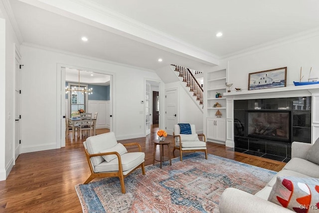 149 E Genesee St, Skaneateles, NY 13152 - living area featuring ornamental molding, built in features, wood finished floors, a chandelier, and a fireplace
