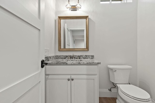 149 E Genesee St, Skaneateles, NY 13152 - half bath featuring vanity, toilet, baseboards, and wood finished floors