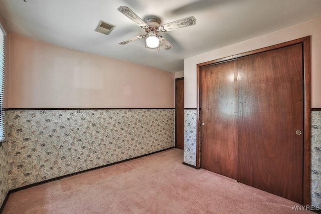 831 W Gebhard Ln, Alden, NY 14004 - unfurnished bedroom with light carpet, a wainscoted wall, a closet, ceiling fan, and wallpapered walls
