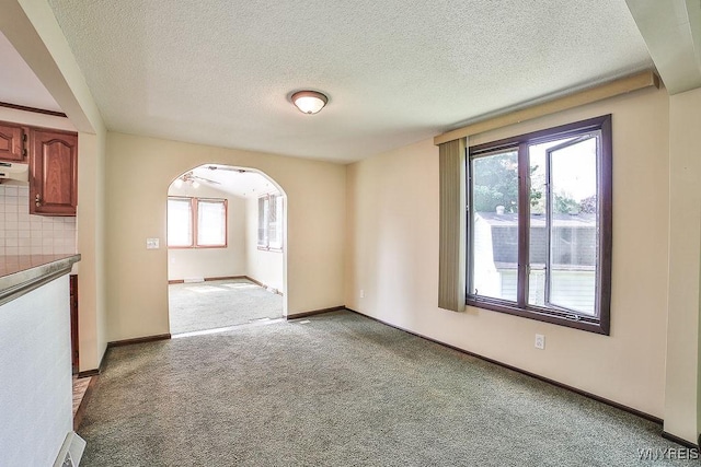 831 W Gebhard Ln, Alden, NY 14004 - carpeted empty room featuring arched walkways, a textured ceiling, and baseboards
