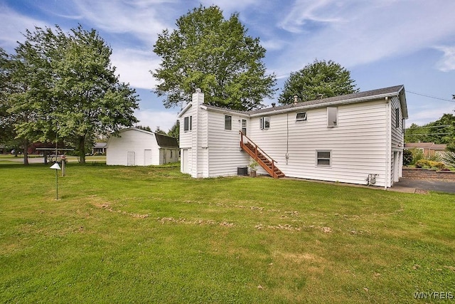 831 W Gebhard Ln, Alden, NY 14004 - back of property with a yard, central AC unit, stairs, and a chimney