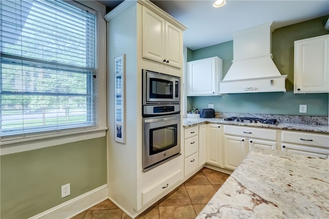 2550 E Ave, Brighton, NY 14610 - kitchen featuring appliances with stainless steel finishes, premium range hood, light tile patterned floors, and light stone countertops