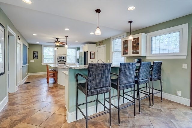 2550 E Ave, Brighton, NY 14610 - kitchen with stainless steel appliances, a peninsula, recessed lighting, glass insert cabinets, and a kitchen bar