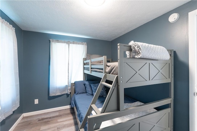 7848 Cold Springs Rd, Urbana, NY 14810 - bedroom featuring light wood-style flooring, a textured ceiling, and baseboards