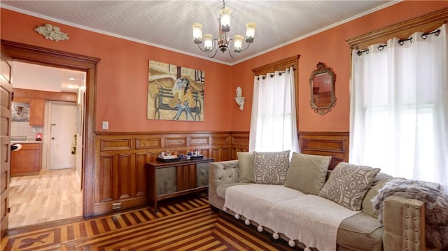 51 Sherrill St Unit 1, Geneva-City, NY 14456 - living area featuring a chandelier, a wainscoted wall, crown molding, and light wood-style floors