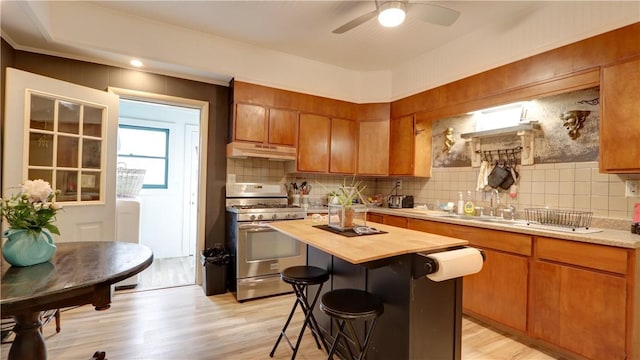 51 Sherrill St Unit 1, Geneva-City, NY 14456 - kitchen with stainless steel range with gas cooktop, wooden counters, under cabinet range hood, backsplash, and ceiling fan