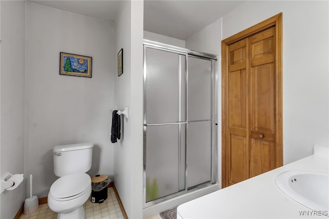 25 5th Ave, Amherst, NY 14221 - bathroom featuring a stall shower, toilet, vanity, tile patterned floors, and baseboards