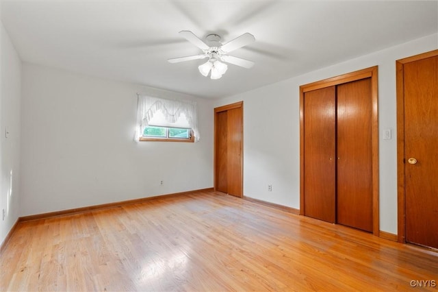 112 Elmcrest Cir, Salina, NY 13090 - unfurnished bedroom featuring two closets, light wood finished floors, baseboards, and ceiling fan