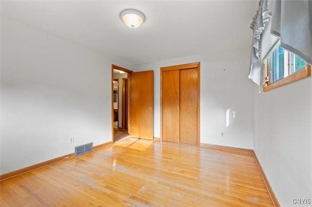 112 Elmcrest Cir, Salina, NY 13090 - unfurnished bedroom featuring wood finished floors, baseboards, and a closet