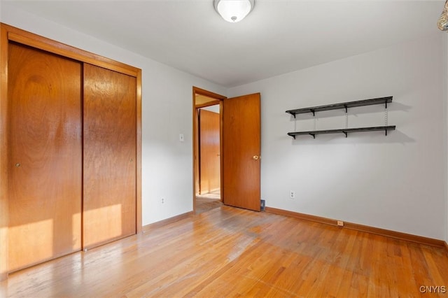 112 Elmcrest Cir, Salina, NY 13090 - unfurnished bedroom featuring light wood-type flooring, baseboards, and a closet